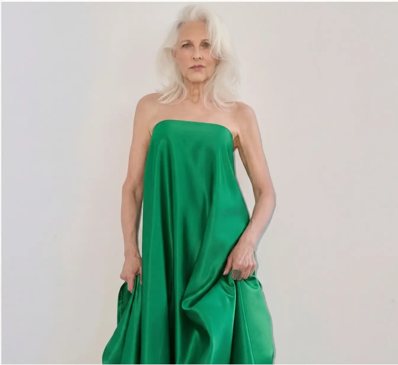 Woman standing in an emerald green strapless gown